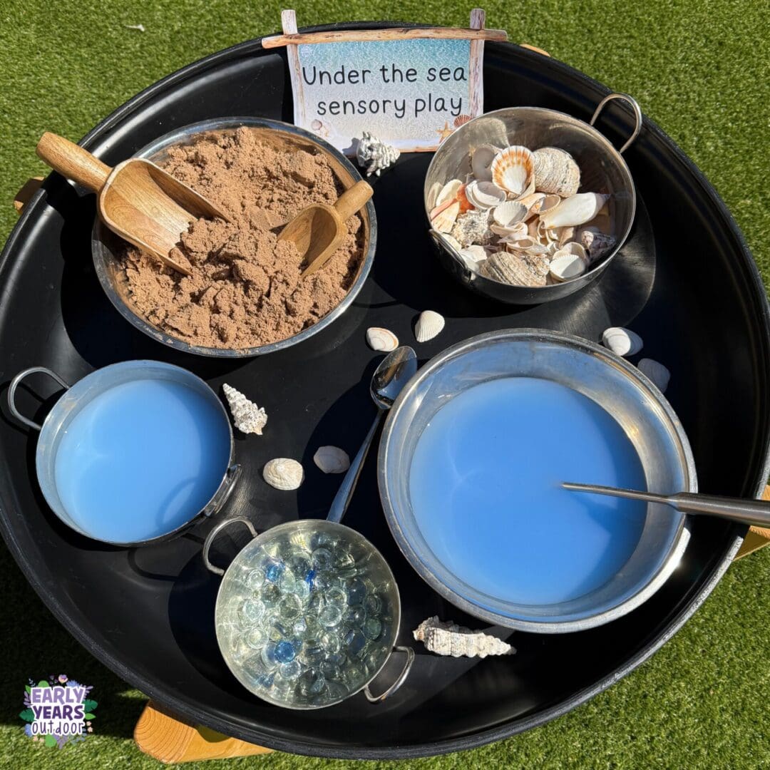 Under the sea sensory play Under the sea sensory play tuff tray with a sign, a bowl of sand with a scoop, blue water, shells, gems and spoons